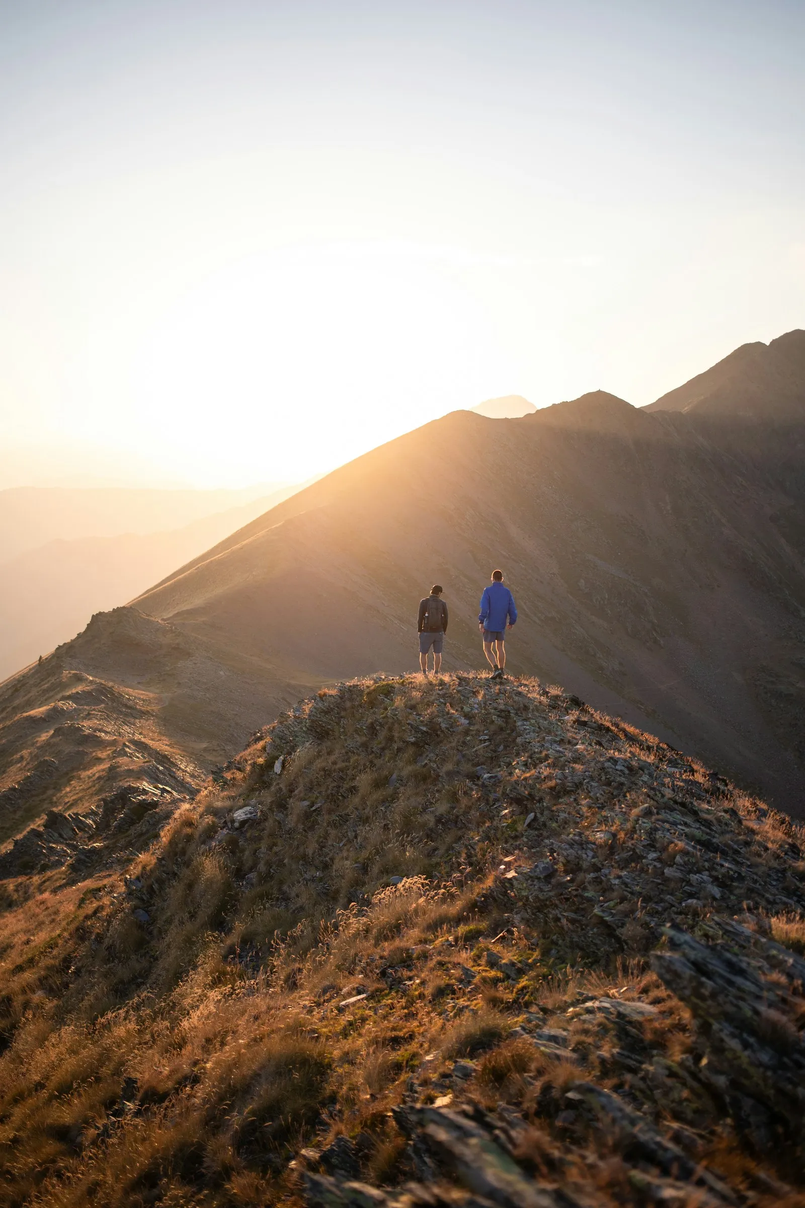 A line of hikers following a narrow ridgeline trail